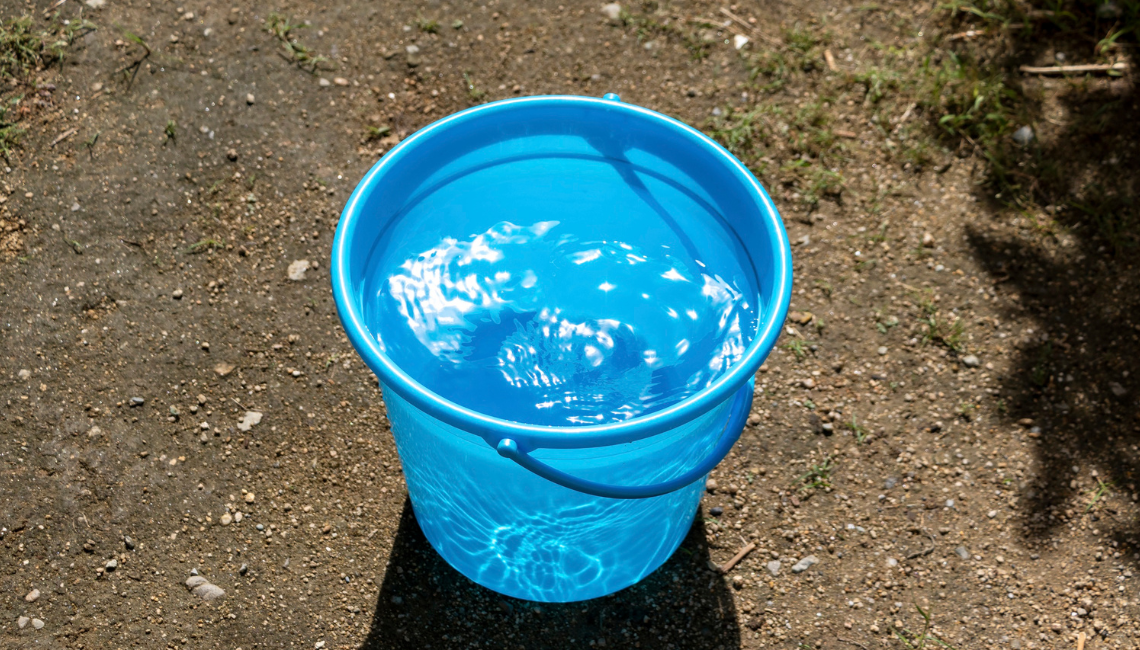 Blue bucket almost filled up with water