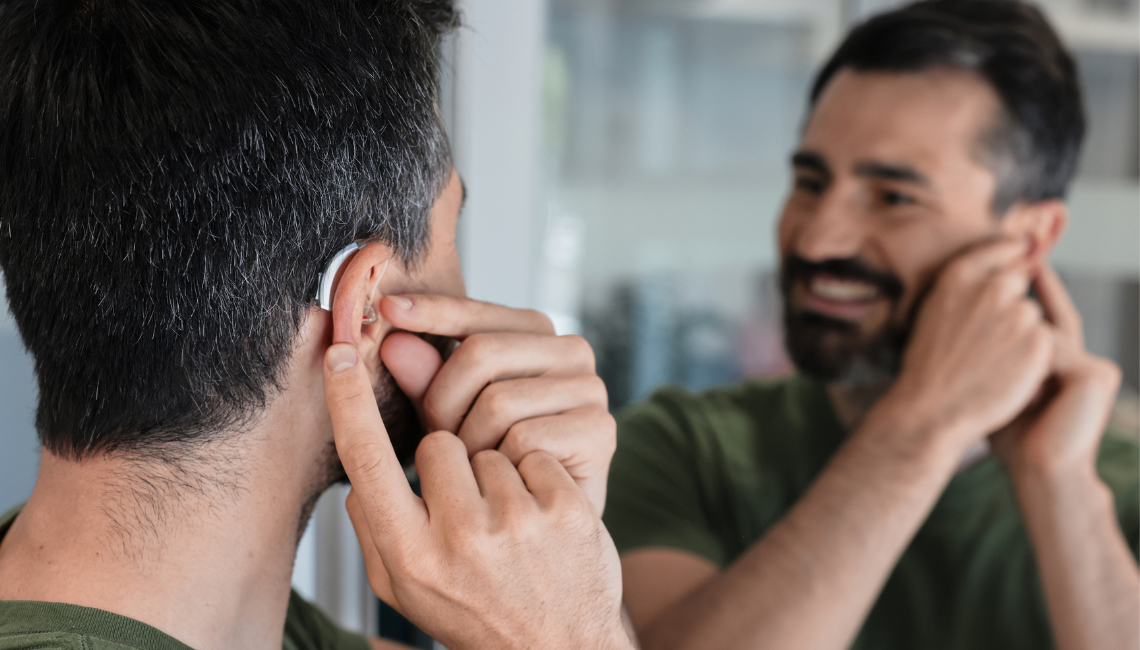 Man placing a hearing aid in his ear