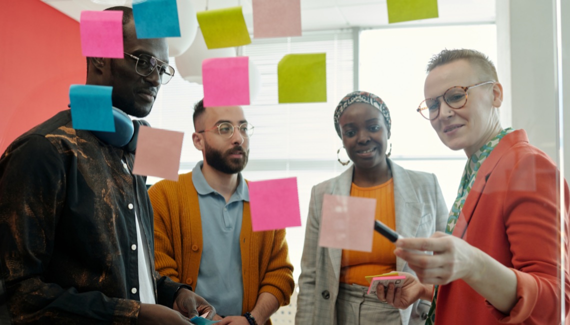 Group of colleagues planning together with sticky notes, representing collaborative workplace inclusion activities.