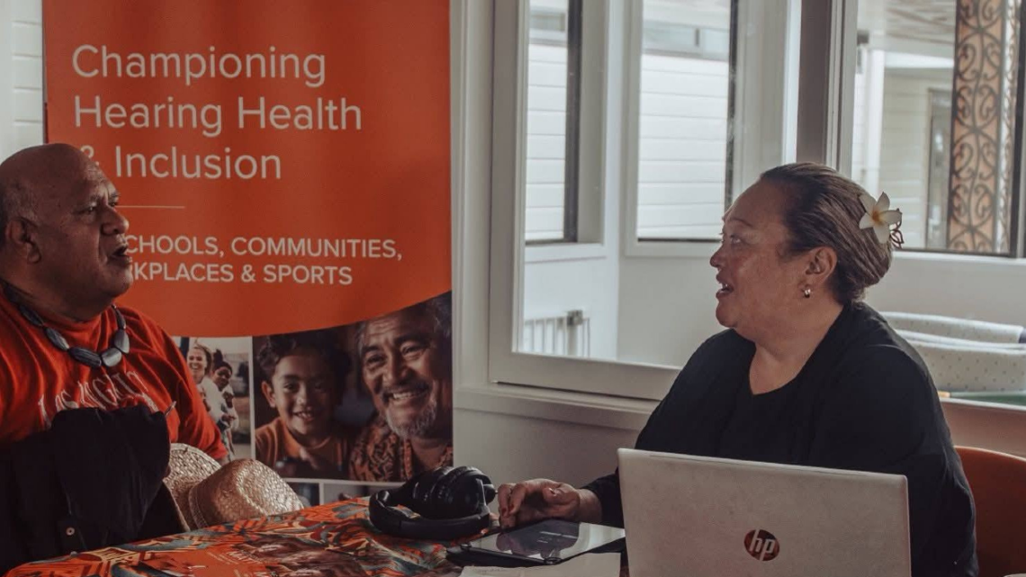 Man and DHHF staff member sit together, showing warmth, connection, and support in the Pasifika community.