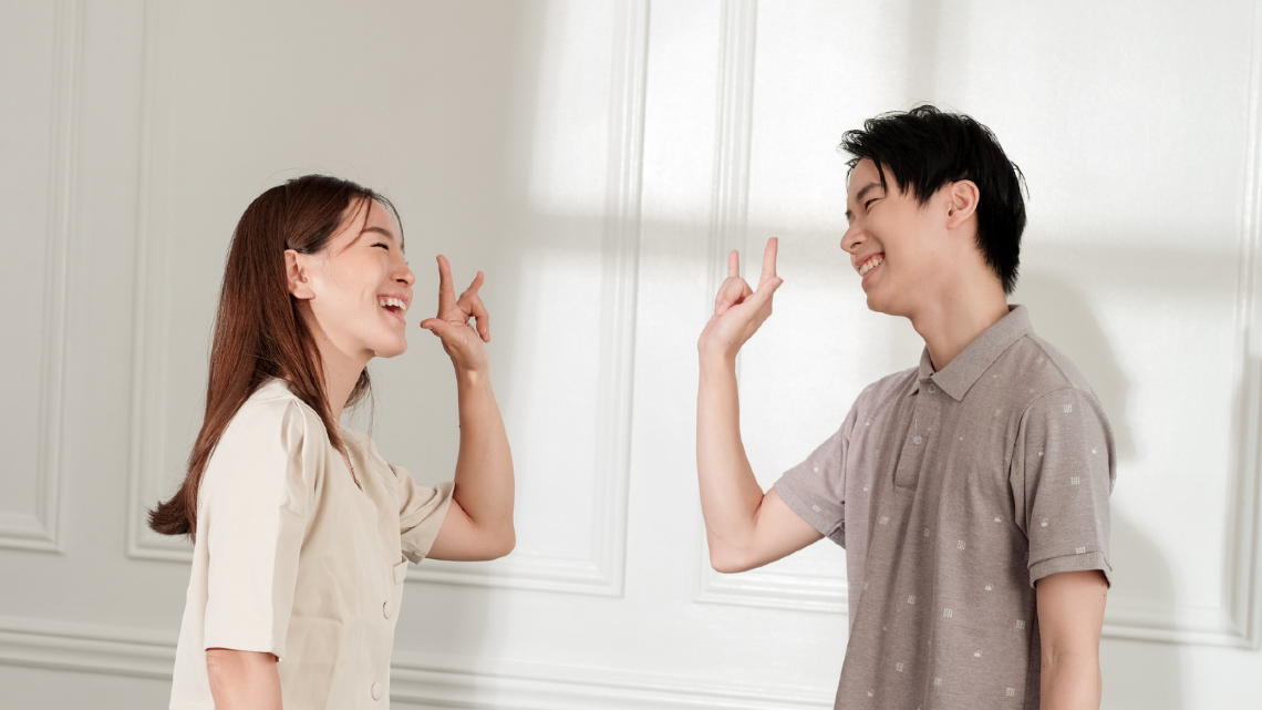 A couple saying Í love you in sign language.