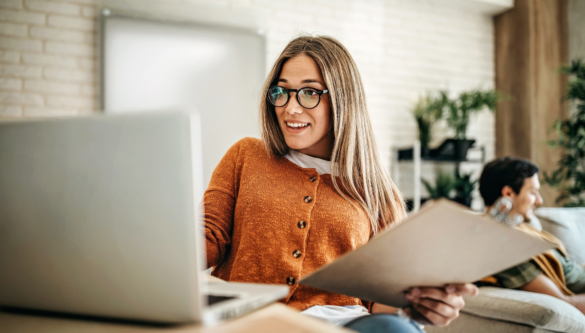 Woman sitting at a desk in front of her laptop smiling