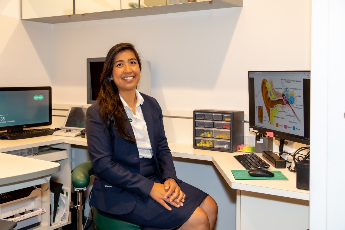 Carmela sitting at her desk at work