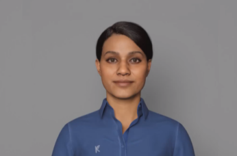Female-presenting digital avatar in a blue collared shirt, facing forward on a plain grey background, representing NZSL technology.