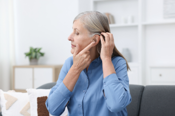 Woman with long grey hair wearing a hearing aid