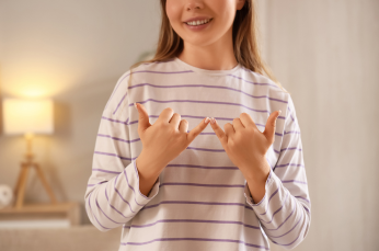 Picture of a woman with a stripey long sleeve t-shirt signing