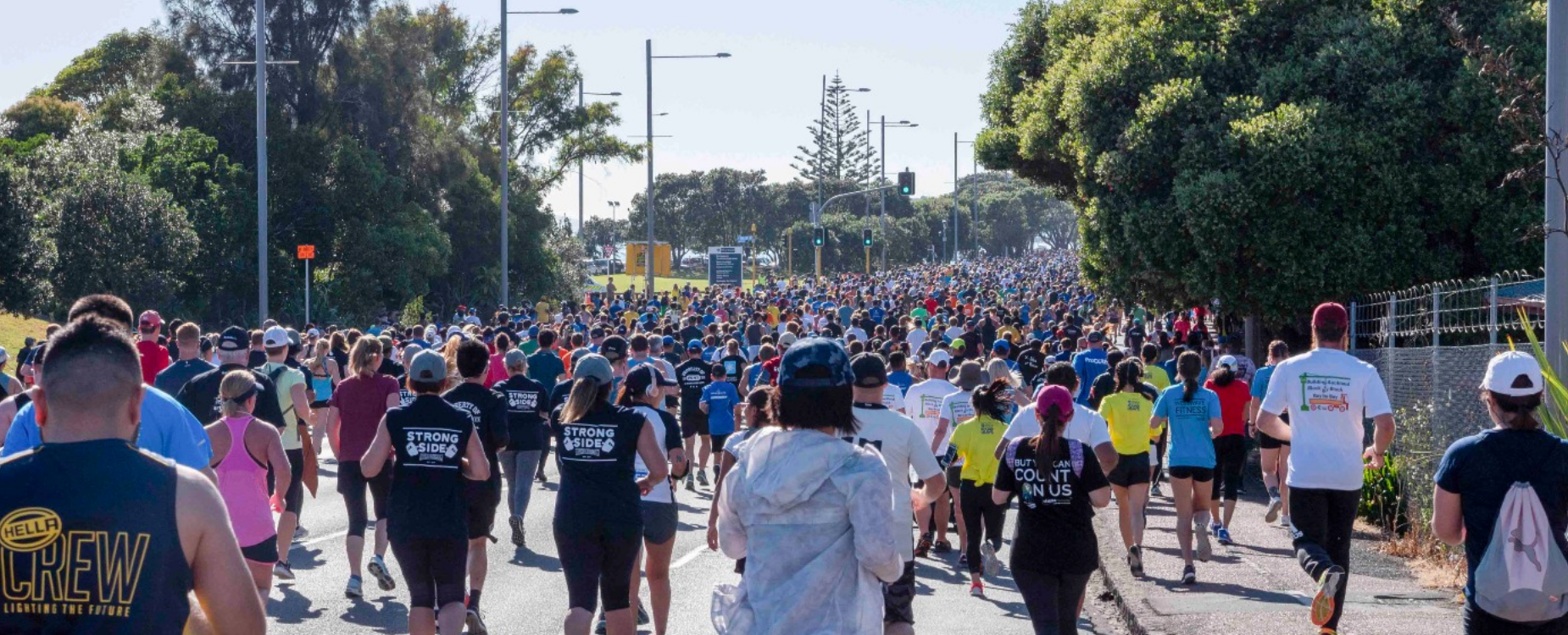 Large number of runners taking part in a running event on a nice sunny day.