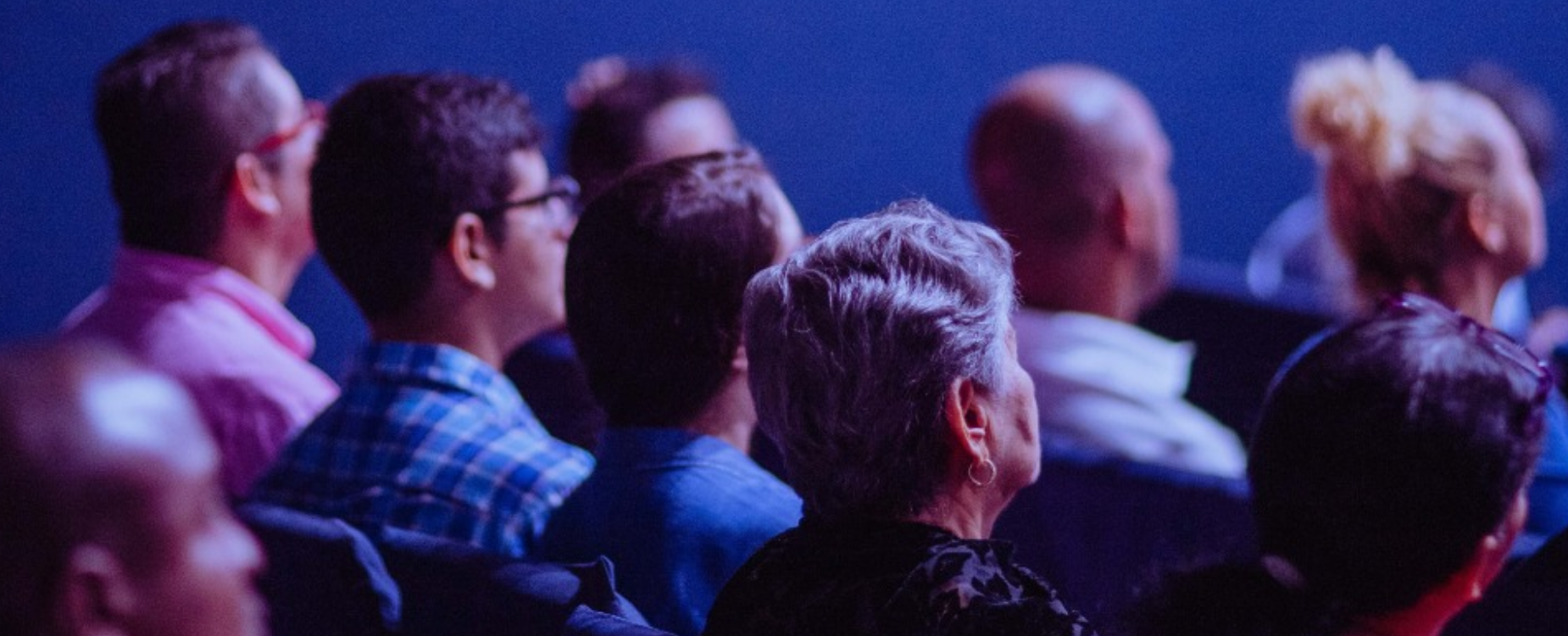 Audience members seated together at an indoor event or presentation.