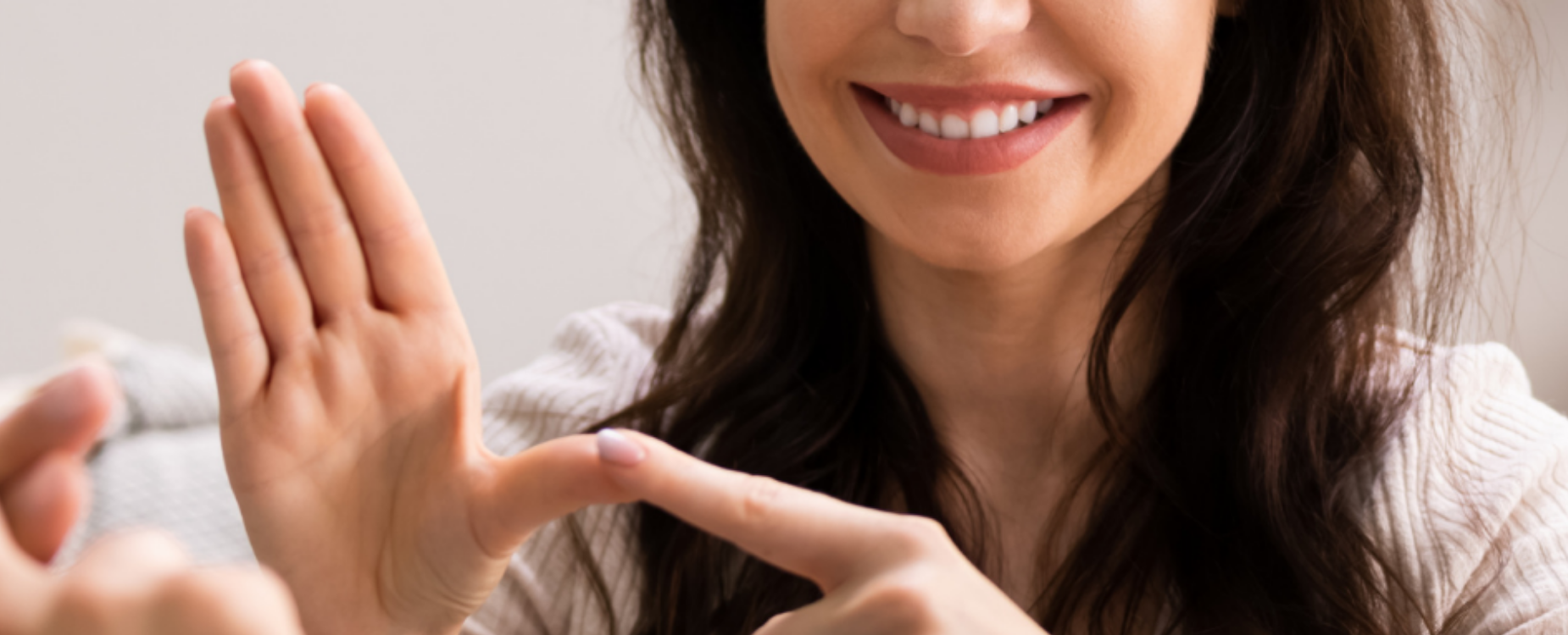 Smiling woman in conversation, representing New Zealand Sign Language communication and connection.