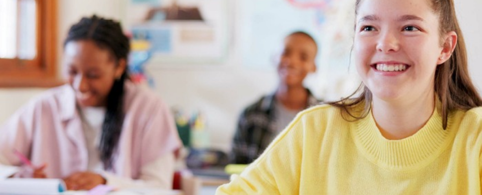 Smiling Year 9 student seated in a classroom prior to the start of a school hearing screening.